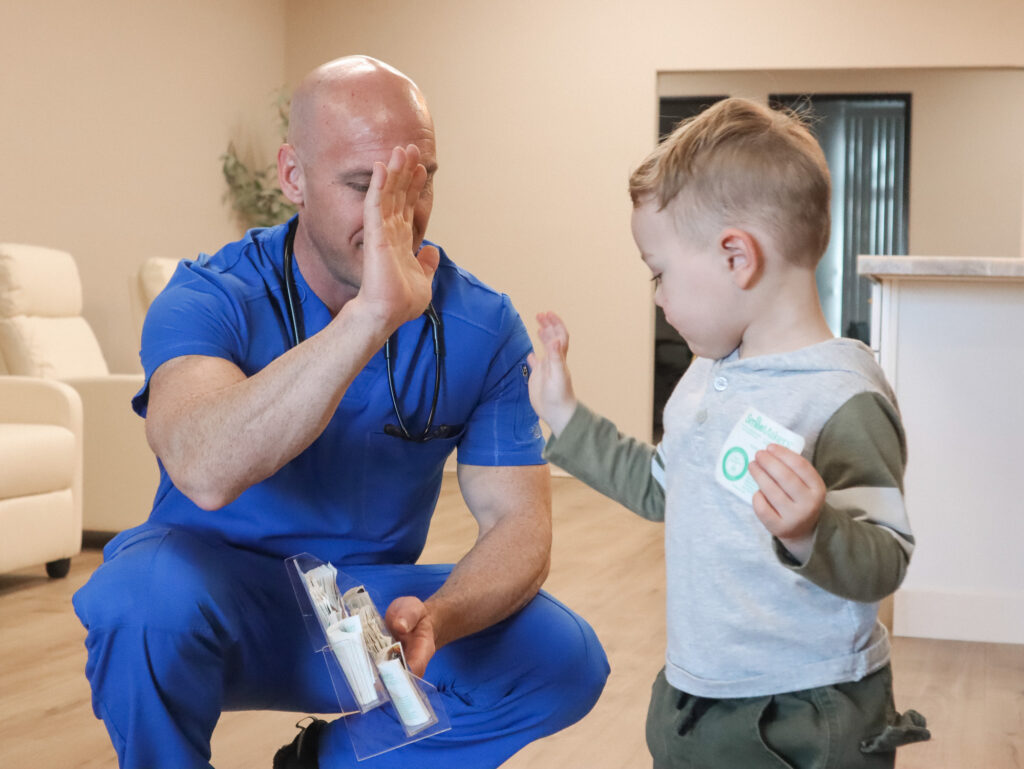 A provider high-fives a child after his appointment with his pediatrician in Reno.